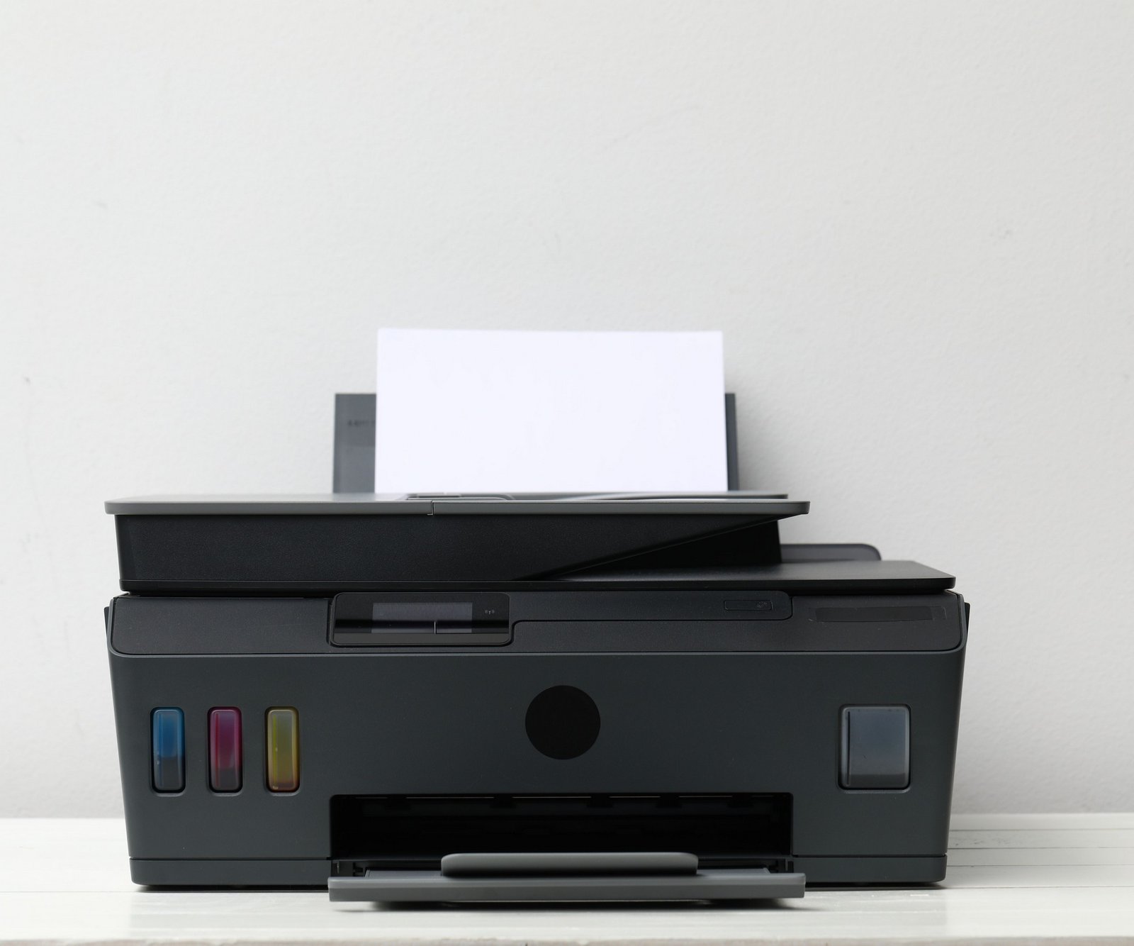 Hand drückt Reset-Knopf an einem Drucker