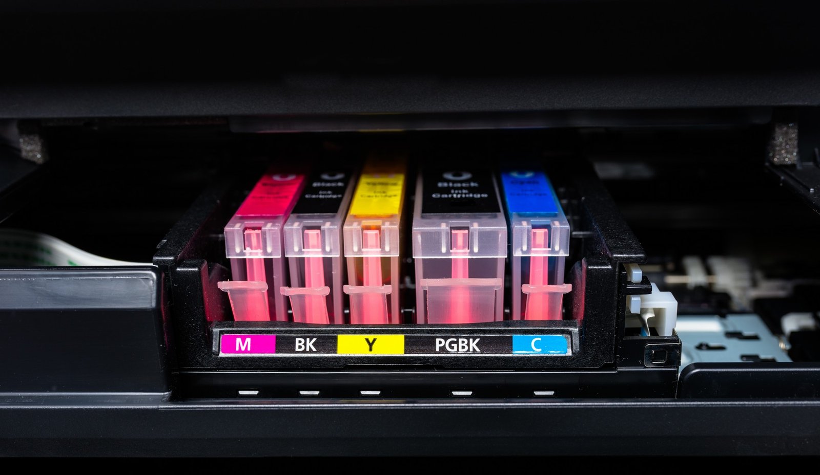 Volle Tintenpatrone liegt neben einem Drucker